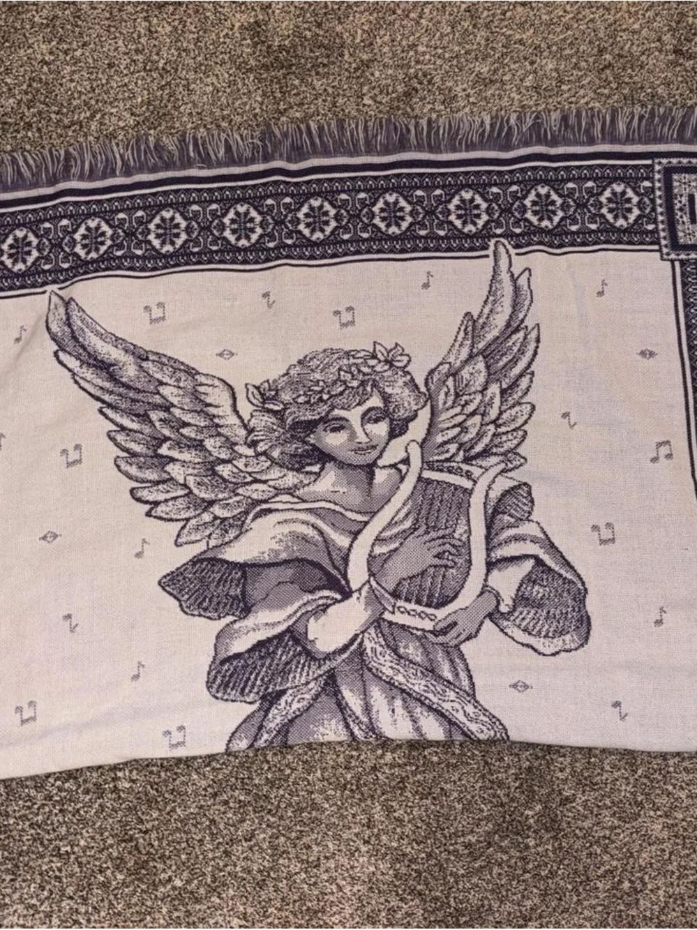 Purple and white tapestry blanket with music notes and angel playing harp
